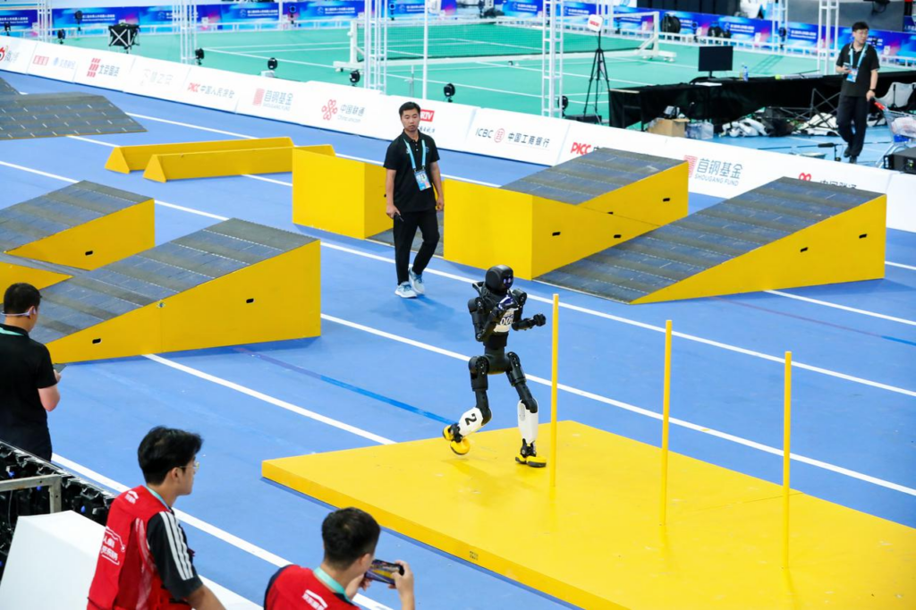 A humanoid robot playing football on the field at the World Humanoid Robot Games 2026.